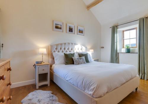 a white bedroom with a large white bed and a window at Nick Jone in Feetham