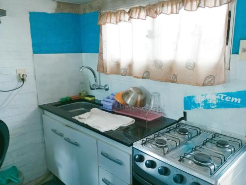 a small kitchen with a stove and a sink at Tu hospedaje soñado in Durazno