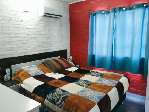 Schlafzimmer mit einem Bett und blauen Vorhängen in der Unterkunft Tu hospedaje soñado in Durazno