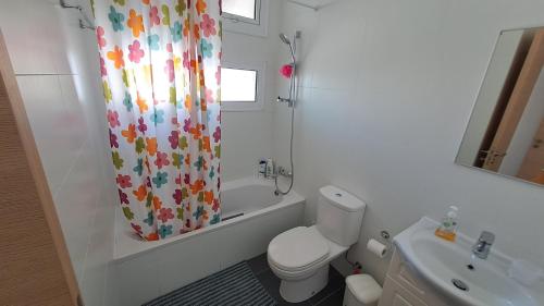 a bathroom with a toilet and a shower curtain at Relaxing Avra Villa with Private Pool & Garden Near Protaras in Paralimni