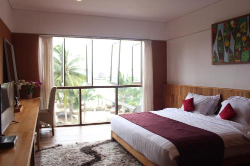 a bedroom with a bed and a large window at Natuna Dive Resort in Ranai