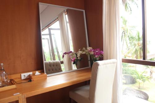 a mirror on a desk in a room with a window at Natuna Dive Resort in Ranai