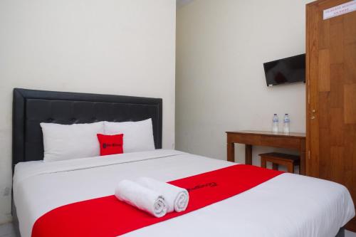 a bedroom with a bed with two towels on it at RedDoorz Syariah near Pakuwon Mall Jogja in Kejayan
