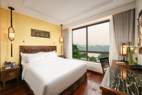 San Grand Hotel & Spa في هانوي: غرفة نوم بسرير كبير ونافذة كبيرة