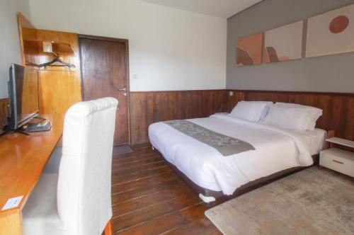 a bedroom with a large bed and a television at Natuna Dive Resort in Ranai