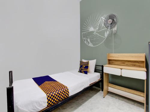 Cette chambre comprend deux lits et un ventilateur. dans l'établissement SPOT ON 92490 Casa Homestay Syariah, à Brangsong