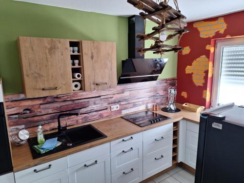 une cuisine avec un comptoir avec un mur en bois dans l'établissement Wohnung Emilia, à Mörfelden-Walldorf