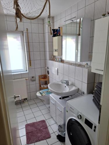 a bathroom with a sink and a washing machine in it at Wohnung Emilia in Mörfelden-Walldorf