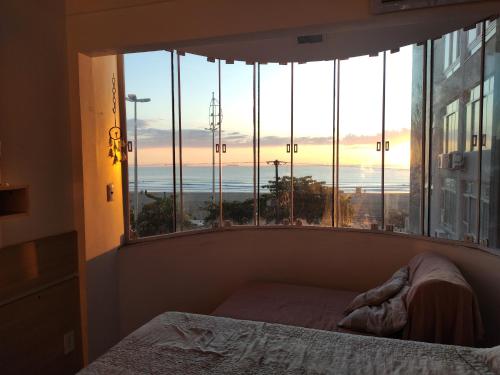 1 dormitorio con ventana y vistas al océano en Ap. frente mar Balneário Camboriú, en Balneário Camboriú