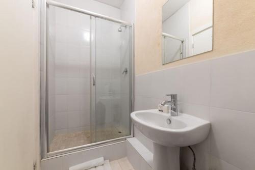 a white bathroom with a sink and a shower at St James. Lantana 36 . Beautiful 2 bed apartment in Saint James