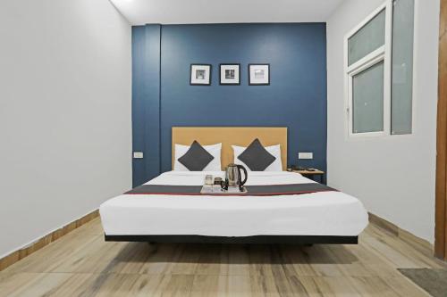 - une chambre avec un grand lit et un mur bleu dans l'établissement Townhouse 819 Peeragarhi Chowk, à New Delhi