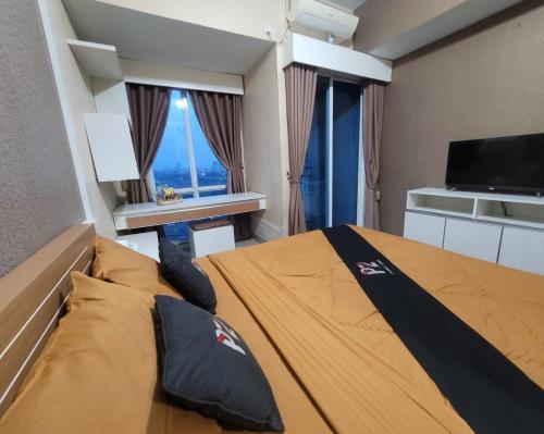 een slaapkamer met een bed en een groot raam bij Apartemen grand dhika city by PLANET ZONA in Padurenan