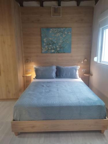 a bedroom with a large bed with a blue blanket at Sweet cottage in Chanioporta in Heraklio