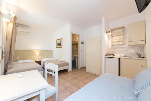 a small room with two beds and a kitchen at Rocco's studios in Antiparos Town