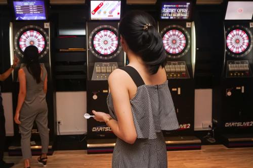 a woman playing darts in a bowling alley at AP Premier Batam in Nagoya