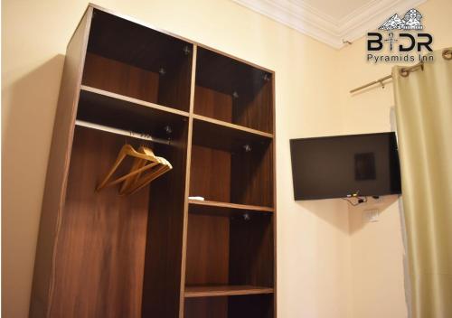 a wooden closet with a tv in a room at Badr pyramids inn in Cairo