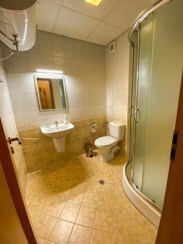 a bathroom with a toilet and a sink and a shower at Panorama View-Stoykite in Stoykite