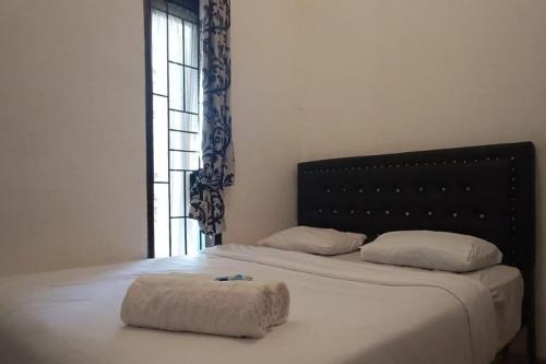 - une chambre avec un grand lit et une grande fenêtre dans l'établissement RedDoorz Syariah at Galliano Homestay Bukittinggi, à Bukittinggi