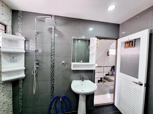 La salle de bains est pourvue d'un lavabo et d'une douche. dans l'établissement Cody Backpackers CNX, à Chiang Mai