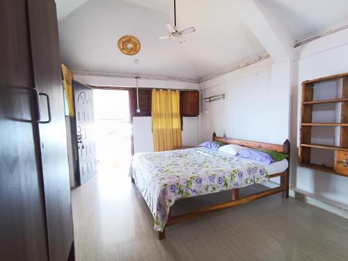 - une chambre avec un lit dans une pièce dotée d'une fenêtre dans l'établissement Monsoon, à Agonda