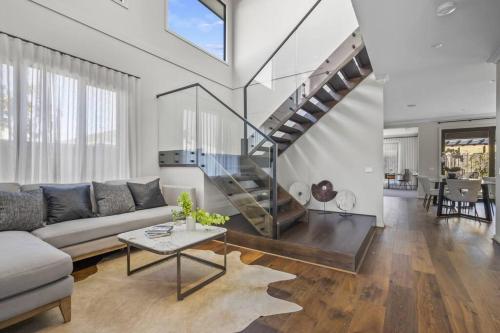 a living room with a couch and a staircase at Werribee Gem Luxe Home Family Getaway 6Bed Netflix in Werribee