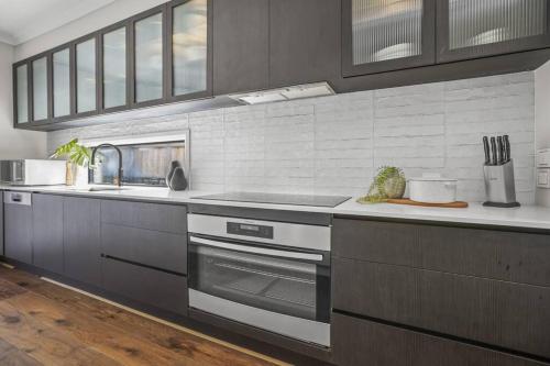 a kitchen with a sink and a stove at Werribee Gem Luxe Home Family Getaway 6Bed Netflix in Werribee