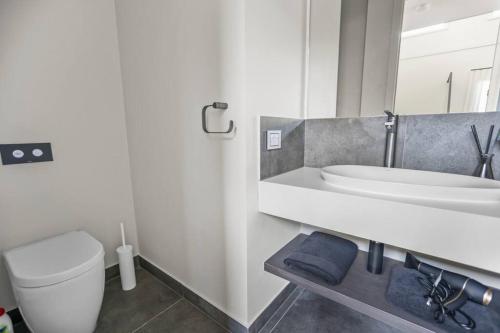 a white bathroom with a sink and a toilet at Werribee Gem Luxe Home Family Getaway 6Bed Netflix in Werribee