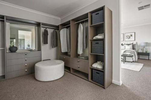 a bedroom with a large closet with a stool in it at Werribee Gem Luxe Home Family Getaway 6Bed Netflix in Werribee