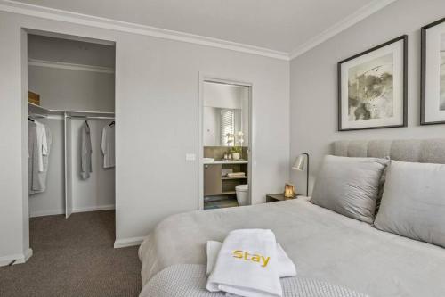 a bedroom with a bed with a stay pillow on it at Werribee Gem Luxe Home Family Getaway 6Bed Netflix in Werribee
