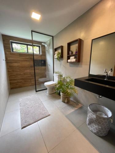 a bathroom with a sink and a toilet and a mirror at Chalé Litoral Norte - em condomínio de praia in Camaçari