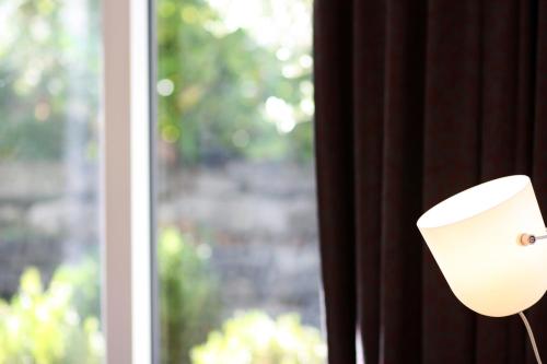 a white lamp is next to a window at Konstanzer Ferienwohnungen in Konstanz