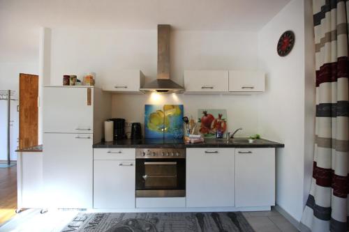 a kitchen with white cabinets and a stove at Konstanzer Ferienwohnungen in Konstanz