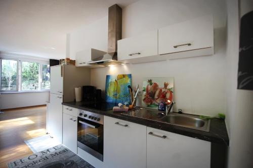 a kitchen with white cabinets and a sink at Konstanzer Ferienwohnungen in Konstanz