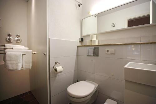 a white bathroom with a toilet and a sink at Konstanzer Ferienwohnungen in Konstanz