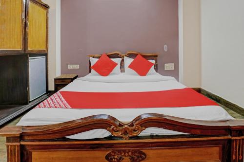 a bedroom with a large wooden bed with red pillows at Hotel O Royal Grand Residency Near Lalbagh Botanical Garden in Bengaluru