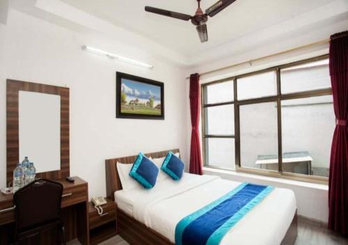 a bedroom with a bed and a desk and a window at Three Brothers Apartment and Hotel in Kathmandu