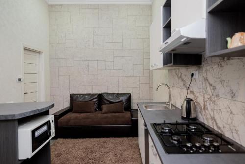 - une cuisine avec une cuisinière et un canapé dans la chambre dans l'établissement Studio Rentals, à Chişinău