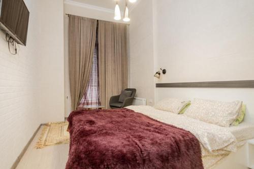 - une chambre avec un lit, une chaise et une fenêtre dans l'établissement Studio Rentals, à Chişinău