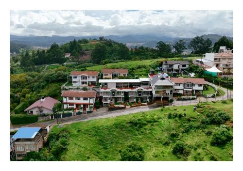 an aerial view of a village with houses on a hill at Fortune Retreats in Ooty