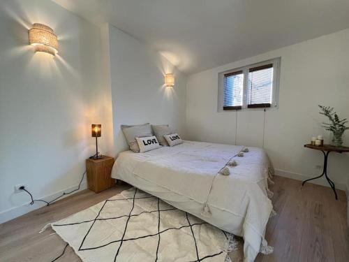 biała sypialnia z dużym łóżkiem i dywanem w obiekcie Loft d'artiste coeur de Vendôme Caroline Paul Officiel w mieście Vendôme