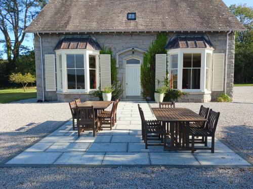 a table and chairs in front of a building at Auchenvhin - Rockcliffe in Dalbeattie