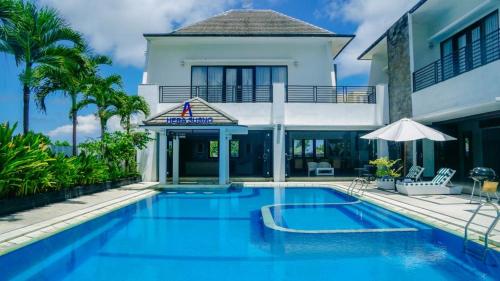 a swimming pool in front of a house at Aldeoz Villa Nusa Dua in Nusa Dua