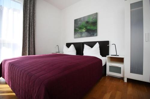 a bedroom with a bed with a purple bedspread at Konstanzer Ferienwohnungen in Konstanz