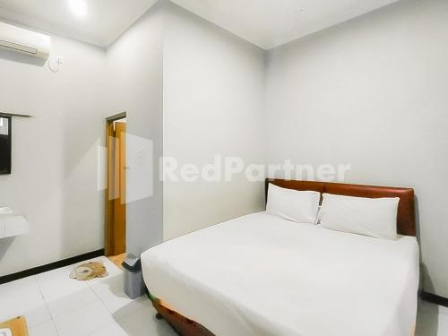 En eller flere senge i et værelse på Indah Savana Hotel Mitra RedDoorz