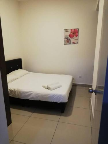 Bett in einem Zimmer mit einem Bild an der Wand in der Unterkunft SmileHome - Palas Horizon Residence 3R2B Brinchang in Brinchang