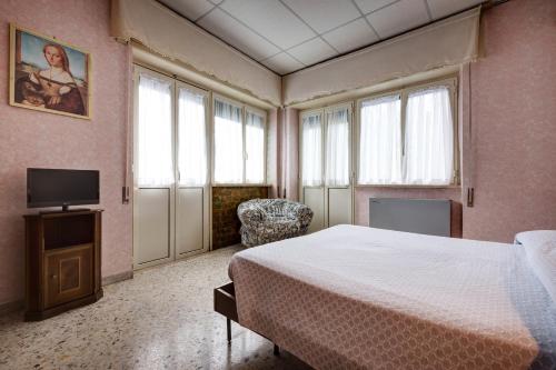 a bedroom with a bed and a tv and windows at Hotel Ristorante Stella in Palestrina