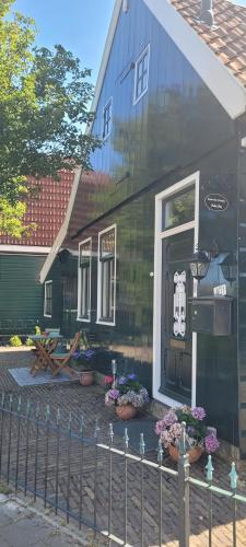 a black house with a fence in front of it at Boutique B&B Dolce Due in Assendelft