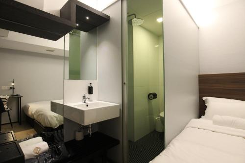 ein Bad mit einem Waschbecken und einem Bett in der Unterkunft ST Signature Bugis Beach in Singapur