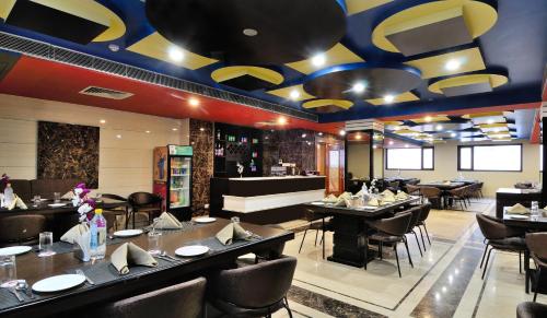 a restaurant with tables and chairs and a bar at Crystal Ganga Heights 5 Min from Har Ki Pauri in Haridwār