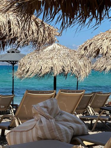 a group of chairs and umbrellas on a beach at Beach Retreat in town in Korinthos